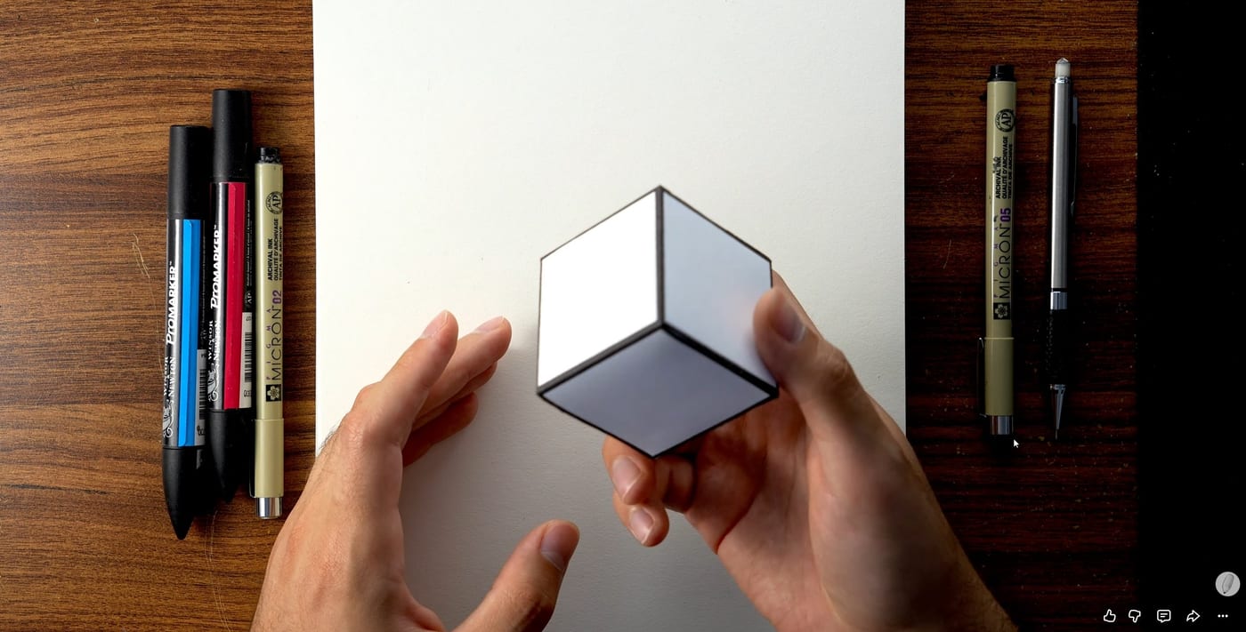 Une main tenant un cube pour montrer la perspective